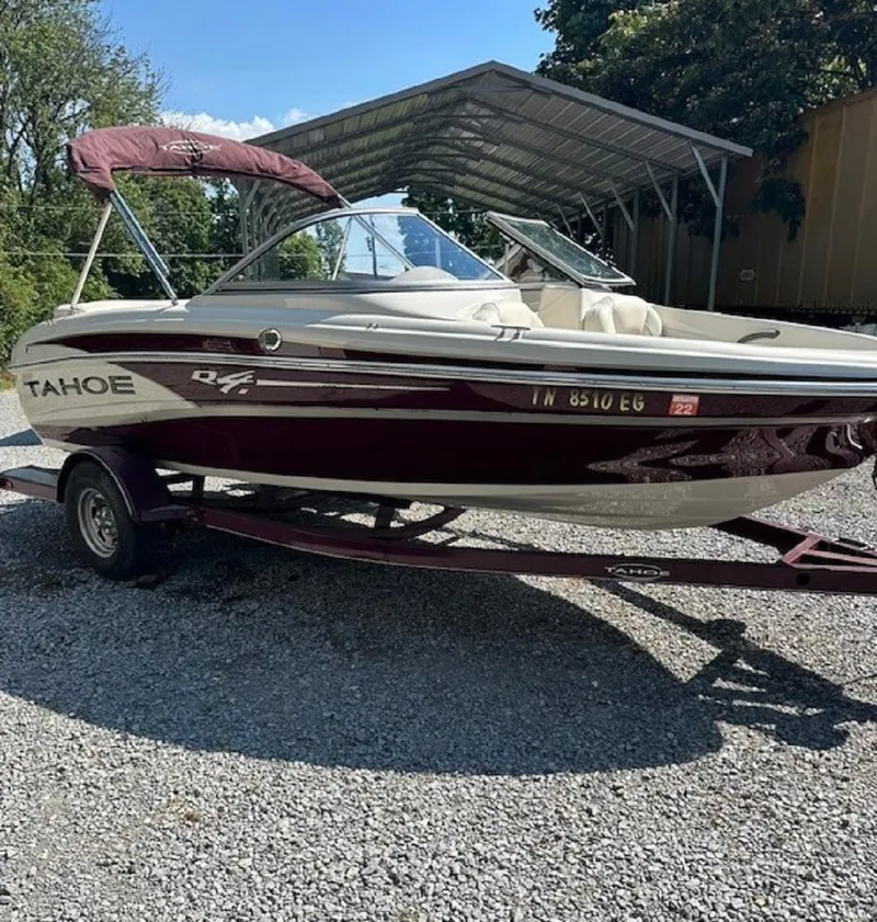 Slide: The Image of 2014 Tahoe Q4i boat on trailer, parked outdoors under a clear sky. - 5