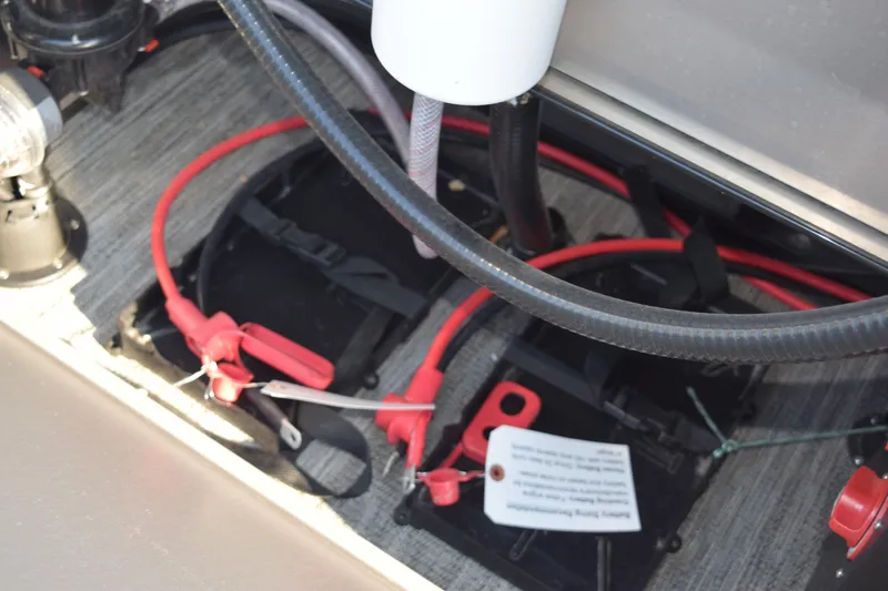 Slide: The Image of 2025 Angler Qwest 8524 ALL SPORT boat battery compartment with cables and connections. - 22