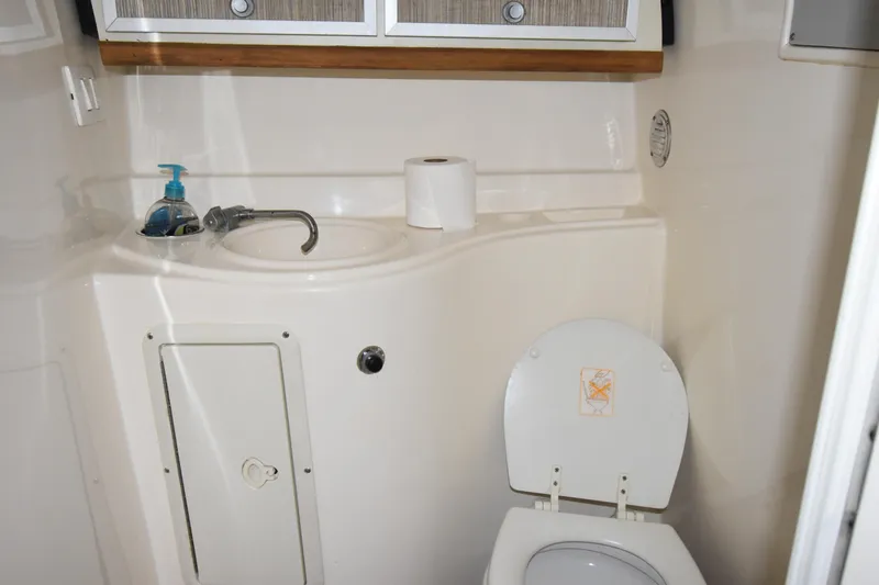 Slide: The Image of 2018 Pronautica 34 boat bathroom with sink, toilet, and storage cabinets. - 16