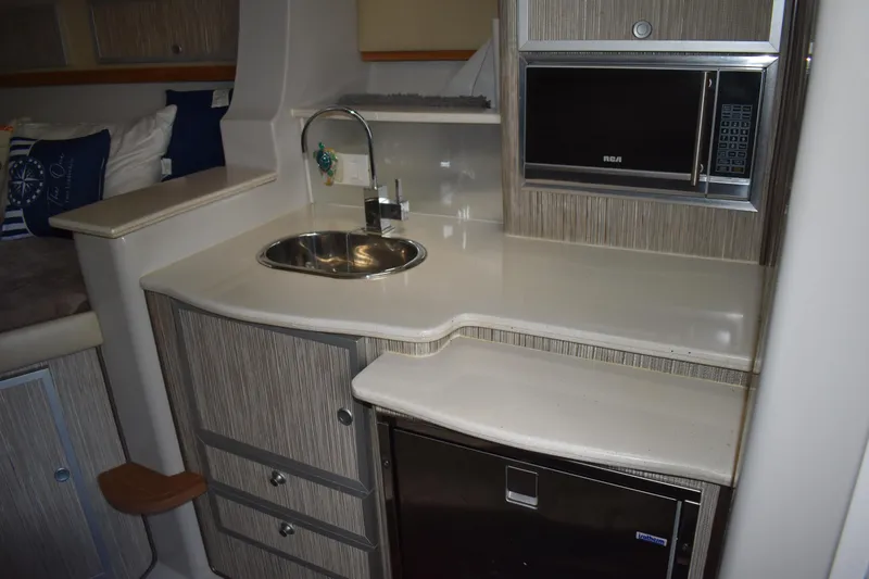 Slide: The Image of 2018 Pronautica 34 yacht interior kitchen with sink, microwave, and storage cabinets. - 25