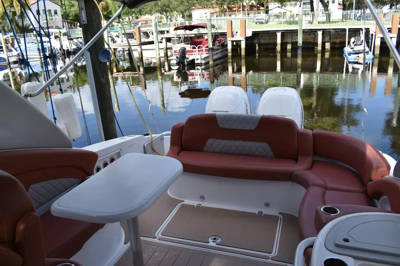 Slide: The Image of 2018 Pronautica 34 boat interior with red seating and table, docked at marina. - 8