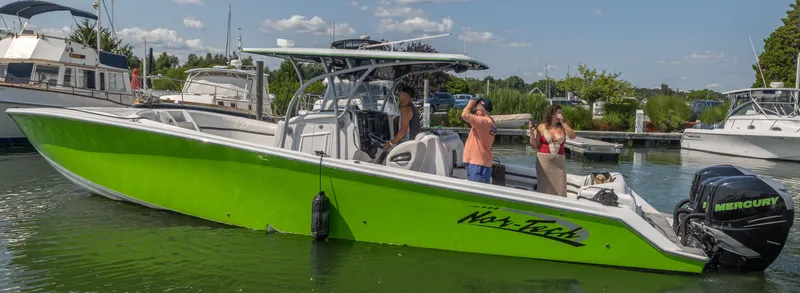 Slide: The Image of 2014 Nor-Tech 390 Sport Cuddy Center Console boat in vibrant green on the water. - 1