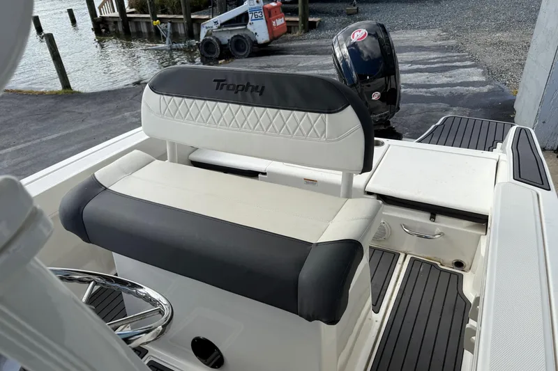 Slide: The Image of 2023 Bayliner Trophy T20CC boat interior with cushioned seating and steering wheel. - 10