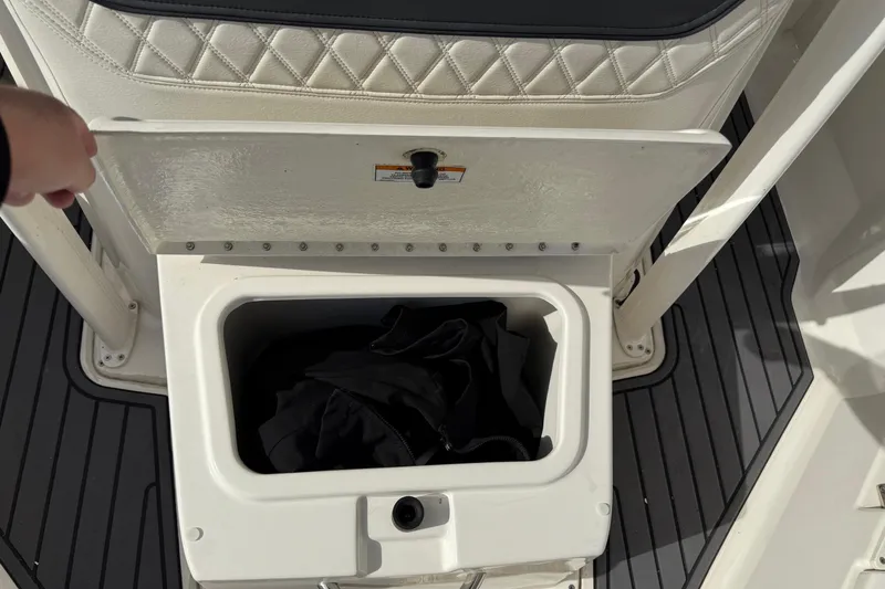 Slide: The Image of 2023 Bayliner Trophy T20CC boat storage compartment with open lid and black fabric inside. - 12