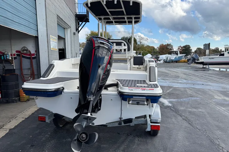 Slide: The Image of 2023 Bayliner Trophy T20CC boat with outboard motor in a marina setting. - 2
