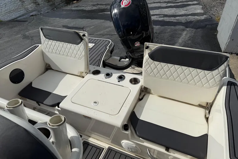 Slide: The Image of 2023 Bayliner Trophy T20CC boat interior with cushioned seating and motor. - 6