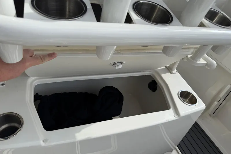 Slide: The Image of 2023 Bayliner Trophy T20CC boat storage compartment with cup holders and rod holders. - 9