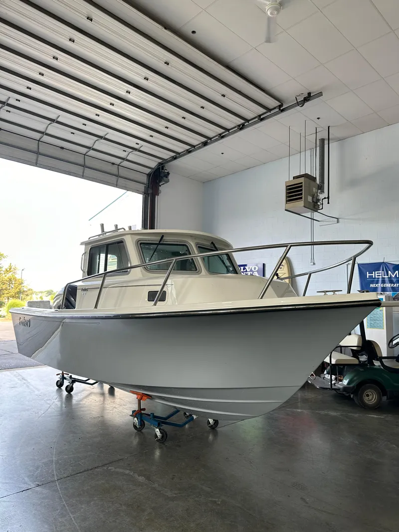 The Image of 2025 Parker 2120 Sport Cabin boat in a spacious indoor garage. - 0