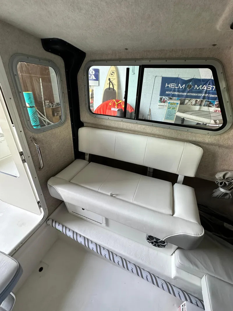 Slide: The Image of Interior of 2025 Parker 2120 Sport Cabin with white seating and window view. - 12