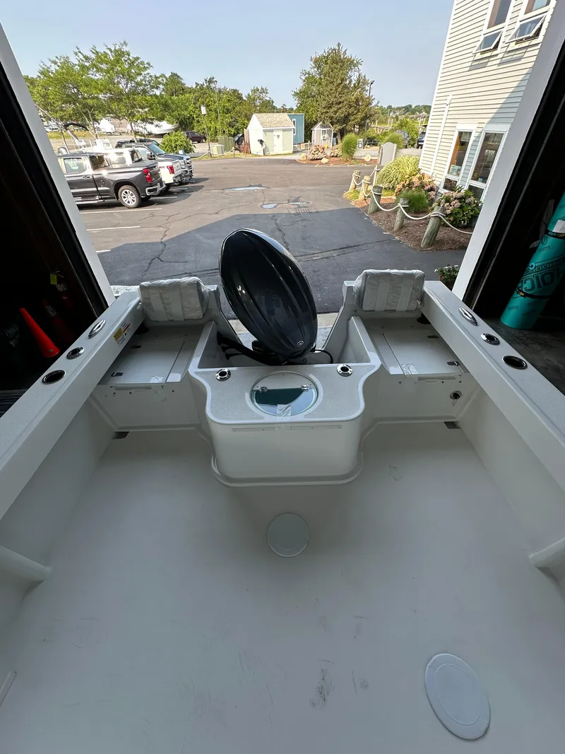 Slide: The Image of 2025 Parker 2120 Sport Cabin boat interior with open hatch, parked outdoors. - 7
