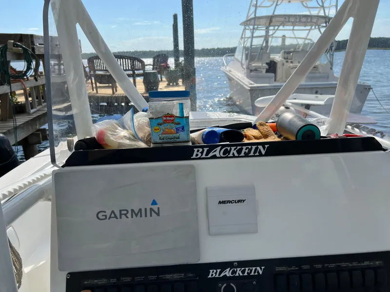 Slide: The Image of 2019 Blackfin 242 CC boat dashboard with Garmin and Mercury equipment at a dock. - 12
