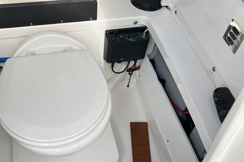 Slide: The Image of 2019 Blackfin 242 CC boat interior with toilet and electrical components. - 15