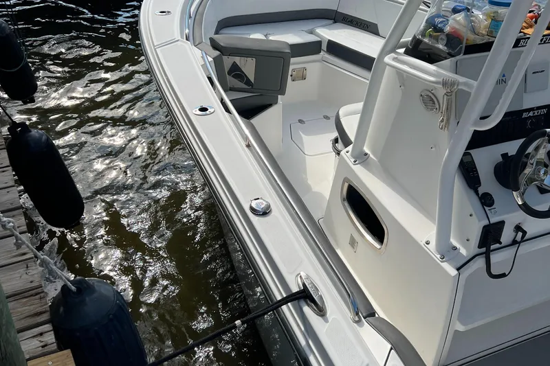 Slide: The Image of 2019 Blackfin 242 CC boat docked, showing interior seating and console. - 4