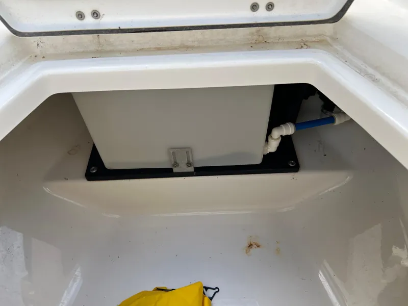Slide: The Image of 2019 Blackfin 242 CC storage compartment with plumbing and yellow item. - 9