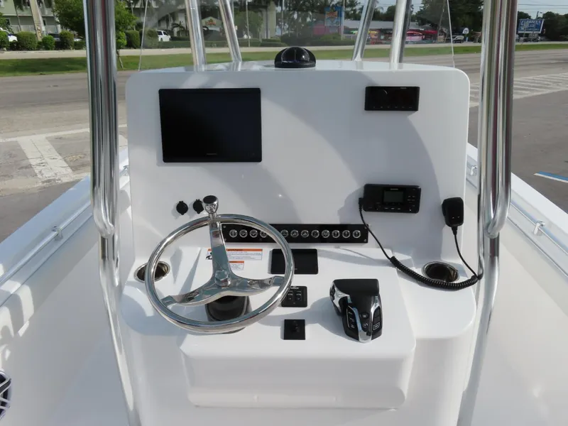 Slide: The Image of 2024 Contender 24S boat console with steering wheel, controls, and navigation equipment. - 12