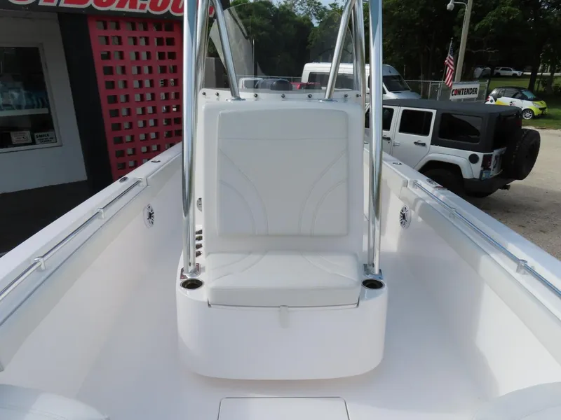 Slide: The Image of 2024 Contender 24S boat interior with seating and console, parked outdoors. - 18