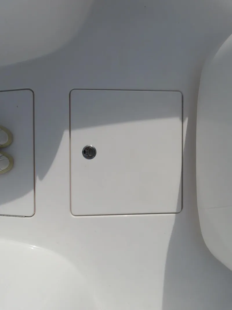 Slide: The Image of Contender 24S 2024 boat deck with storage compartment and latch. - 22