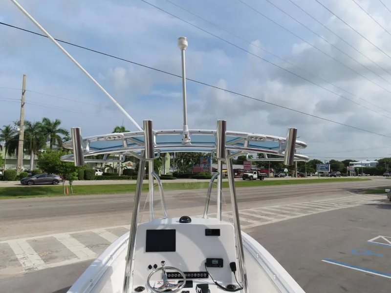Slide: The Image of 2024 Contender 24S boat with T-top and rod holders, parked on a street. - 26