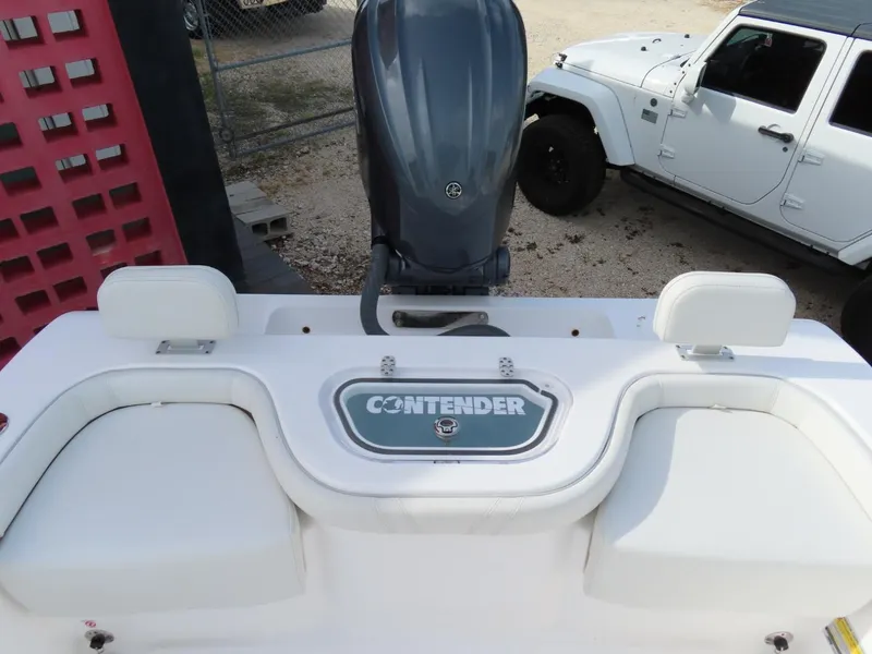 Slide: The Image of 2024 Contender 24S boat with outboard motor, parked near a white Jeep. - 9