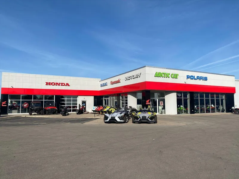 Slide: The Image of Outdoor view of a multi-brand dealership featuring Honda, Suzuki, Kawasaki, Arctic Cat, and Polaris vehicles. - 10