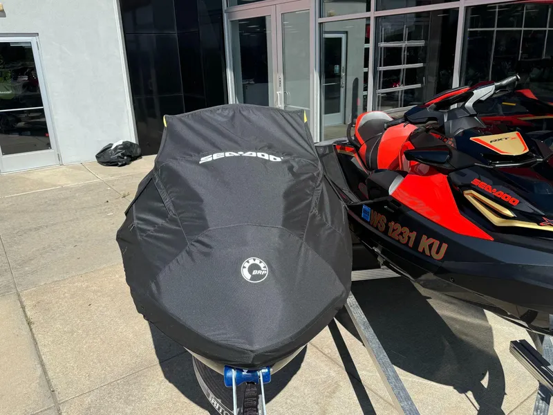 Slide: The Image of 2019 Sea-Doo RXT-X 300 iBR with sound system, partially covered, parked outside a building. - 9