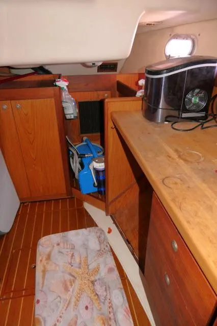Slide: The Image of Interior of a 2000 Hunter 460 sailboat with wooden cabinetry and appliances. - 14