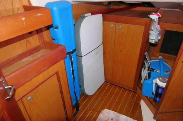 Slide: The Image of Interior of a 2000 Hunter 460 sailboat with wooden cabinets and storage. - 15