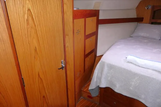 Slide: The Image of Cozy cabin interior of 2000 Hunter 460 yacht with wooden furnishings and bed. - 22