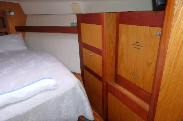 Slide: The Image of Cozy cabin interior of 2000 Hunter 460 sailboat with wooden storage and bed. - 24