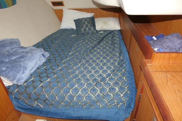 Slide: The Image of Cozy cabin bed in 2000 Hunter 460 sailboat with blue patterned bedding. - 27