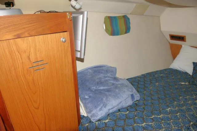 Slide: The Image of Cozy cabin interior of 2000 Hunter 460 sailboat with wooden cabinet and blue bedding. - 28