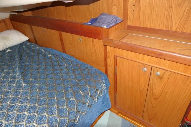 Slide: The Image of Cozy cabin interior of 2000 Hunter 460 sailboat with wooden cabinetry and blue bedding. - 29