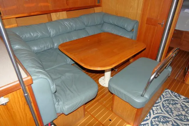 Slide: The Image of Interior of 2000 Hunter 460 yacht with wooden table and blue cushioned seating. - 3