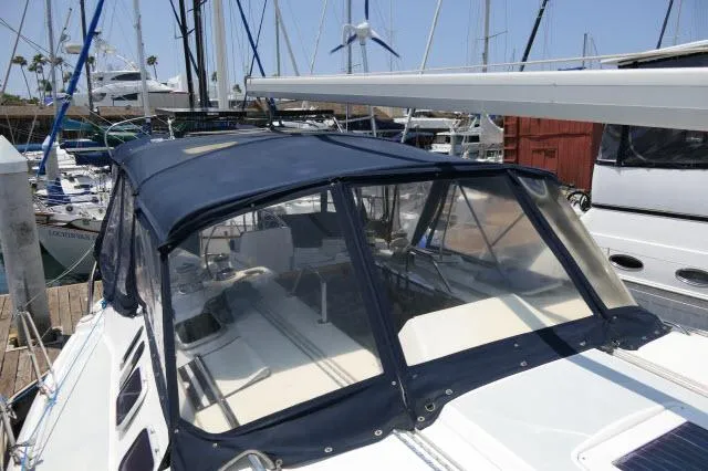 Slide: The Image of 2000 Hunter 460 sailboat with blue canopy docked at marina. - 42