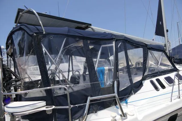 Slide: The Image of 2000 Hunter 460 sailboat with blue canvas enclosure in marina. - 43