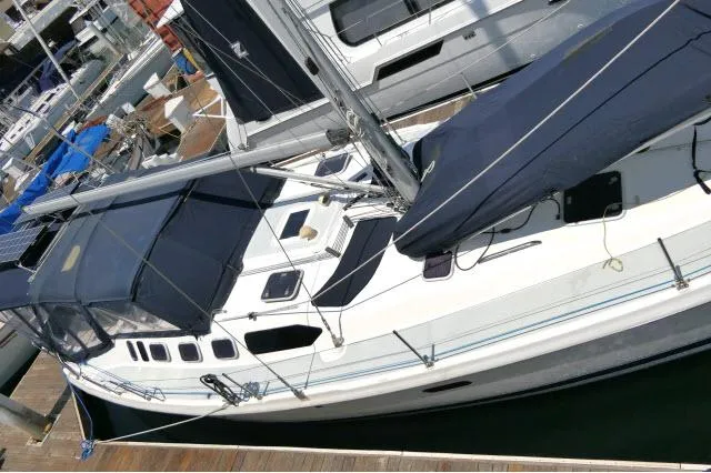 Slide: The Image of Hunter 460 sailboat from 2000 docked at a marina, featuring blue covers. - 47