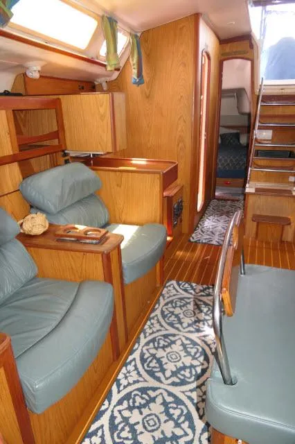 Slide: The Image of Interior of 2000 Hunter 460 sailboat with wood finish and blue seating. - 9