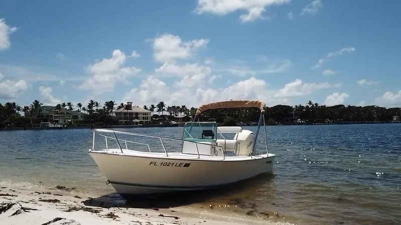 Slide: The Image of 1984 Aquasport 17 CC boat on sandy beach with clear blue sky. - 10