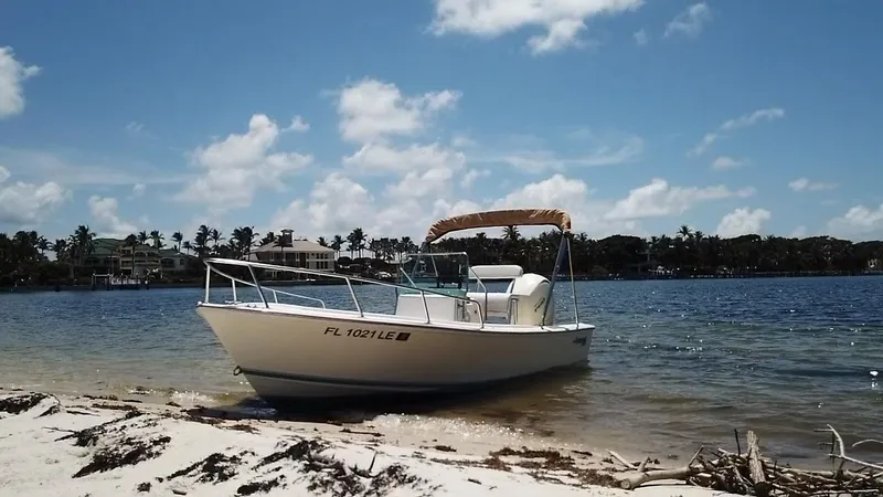 Slide: The Image of 1984 Aquasport 17 CC boat on sandy beach with clear blue sky. - 15