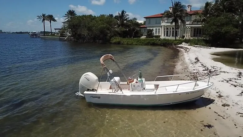 Slide: The Image of 1984 Aquasport 17 CC boat on a sandy beach by waterfront homes. - 8