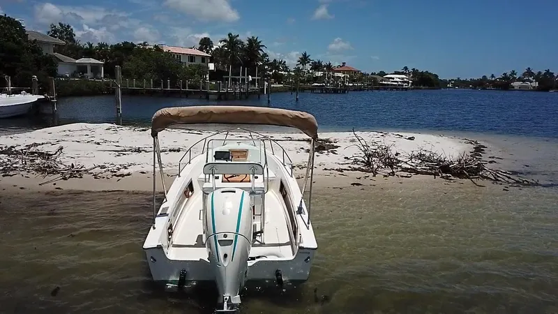 Slide: The Image of 1984 Aquasport 17 CC boat docked on a sandy beach with scenic waterfront view. - 9