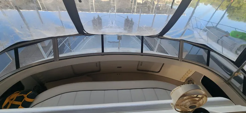 Slide: The Image of 1996 Carver 400 Cockpit Motor Yacht interior with panoramic windows and seating area. - 11