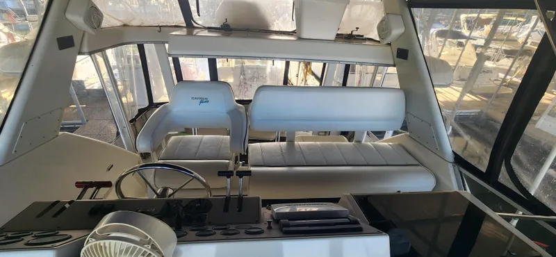 Slide: The Image of Interior of 1996 Carver 400 Cockpit Motor Yacht with white seating and control panel. - 12