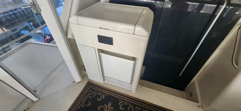 Slide: The Image of Interior of 1996 Carver 400 Cockpit Motor Yacht with storage compartment and decorative rug. - 13