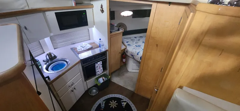Slide: The Image of Interior of 1996 Carver 400 Cockpit Motor Yacht with kitchen and cozy bedroom. - 17