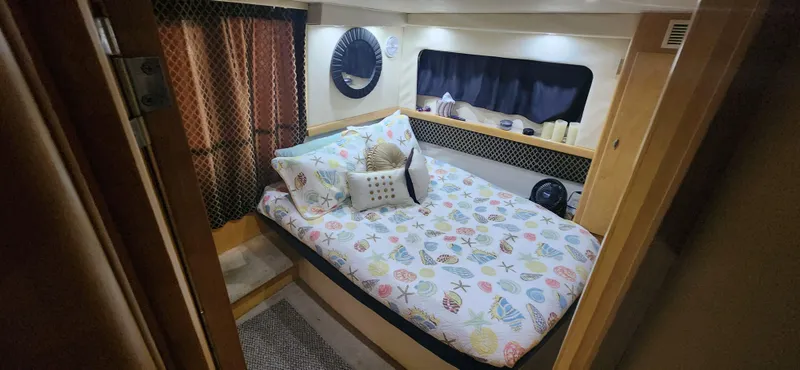 Slide: The Image of Cozy bedroom in 1996 Carver 400 Cockpit Motor Yacht with patterned bedding and decorative pillows. - 21
