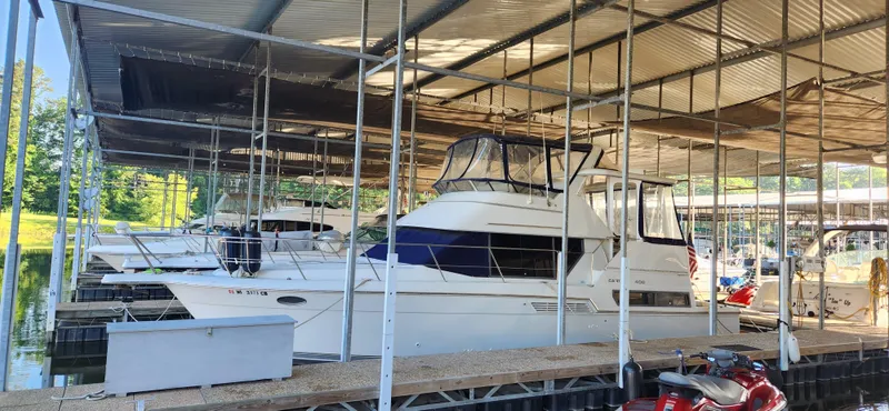 Slide: The Image of 1996 Carver 400 Cockpit Motor Yacht docked in a covered marina. - 3