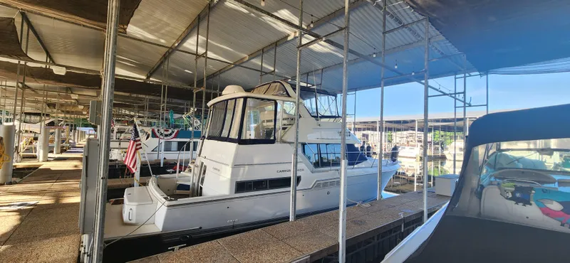 Slide: The Image of 1996 Carver 400 Cockpit Motor Yacht docked in a marina under a covered shelter. - 5