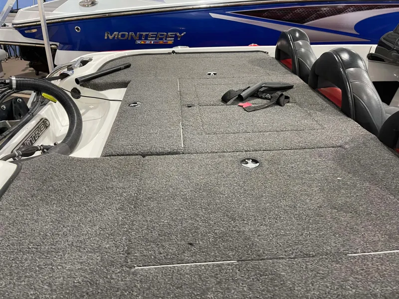 Slide: The Image of 2011 Nitro Z-7 boat interior with carpeted deck and seats, featuring Monterey boat in background. - 12