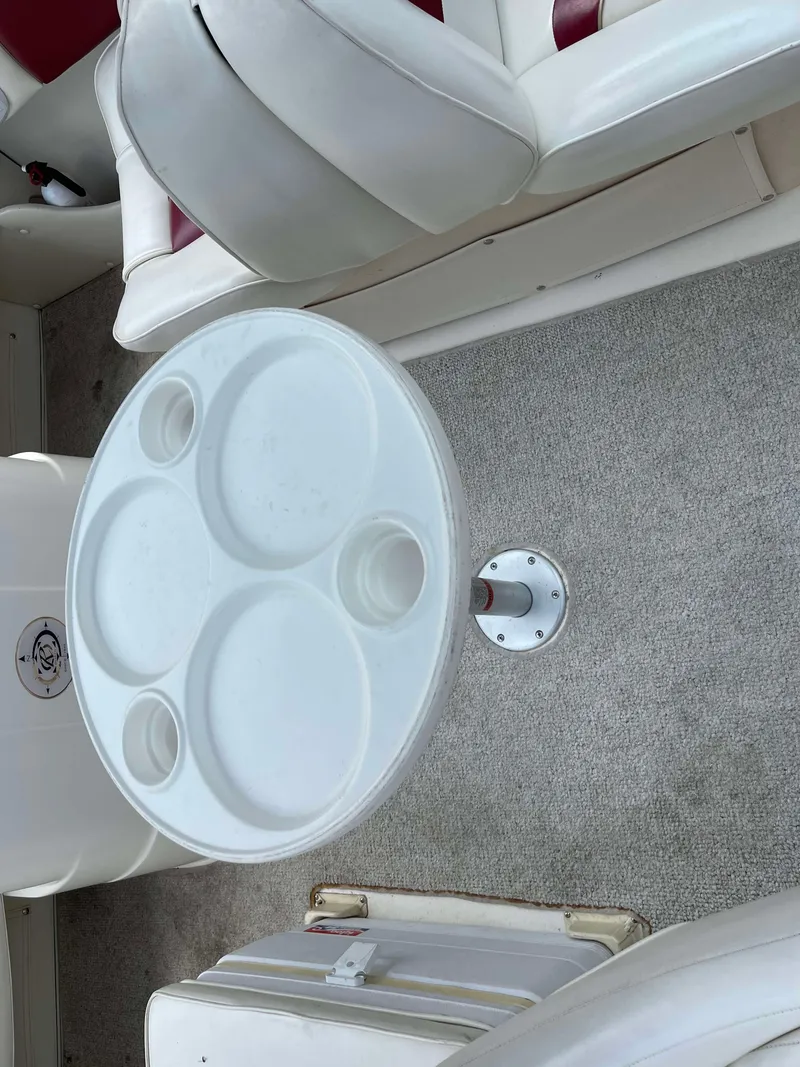Slide: The Image of Interior of 1998 Rinker 212 Captiva Cuddy with white seating and round table. - 11